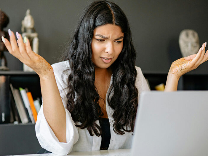 marketing software for nonprofits confusion on woman's face while looking at laptop.