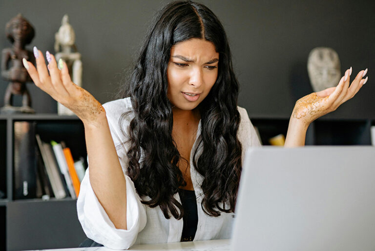 marketing software for nonprofits confusion on woman's face while looking at laptop.